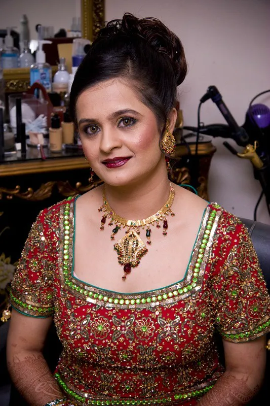 Bridal reception look with red embroidered outfit and glamorous makeup